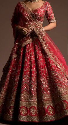 a woman in a red and gold wedding gown with an elaborate necklace on her neck