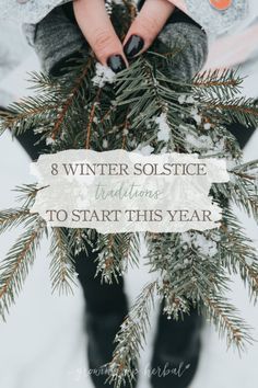 a person holding a pine branch with the words winter solstice written on it