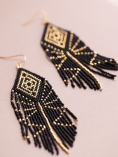 black and gold beaded earrings on a white surface