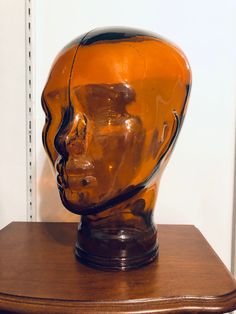 a glass head sitting on top of a wooden table