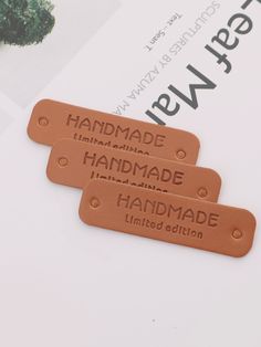 three leather tags that say handmade on them