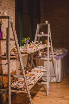 an assortment of desserts are displayed on wooden shelves in the middle of a room