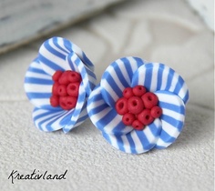 two blue and white striped buttons with red hearts in the center on a white surface