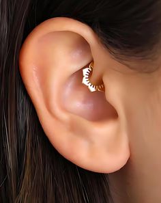 a close up of a person's ear with an earring in the middle