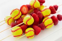 some strawberries and raspberries are arranged on skewers