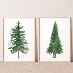 two green watercolor trees on white paper in front of a beige wall and floor