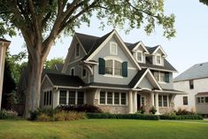 a large house with lots of windows and green shutters