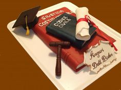 graduation cake made to look like a book, diploma and scroll on top of it