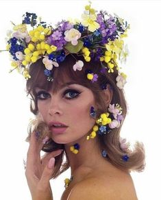 a woman with flowers in her hair posing for the camera and wearing a flower crown