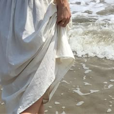 a person standing on the beach with a towel in their hand