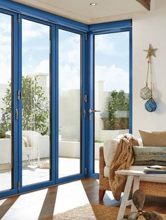 a living room filled with furniture and lots of glass doors that open up to the outside