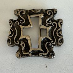 a decorative metal light switch plate on a white wall