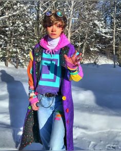 a woman dressed in an odd costume standing in the snow with her hands out and looking at the camera