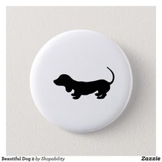 a black and white dachshund dog silhouette on a white button or badge