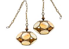 two stained glass lamps hanging from chains on a white background, one is brown and the other is beige