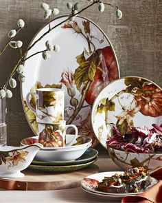 plates, cups and saucers are arranged on a table