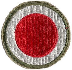 a red and white circular patch with green trim on a white back ground, in the center is an olive green border