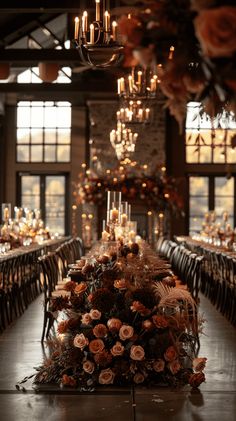 a long table with flowers and candles in the center is set for an elegant dinner