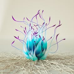 a blue vase sitting on top of a white table next to a pile of seaweed