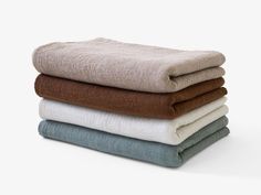 four towels stacked on top of each other in different colors and sizes, all folded together