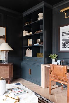 a living room with black walls and wooden furniture