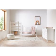 a baby's room with a white crib and dresser