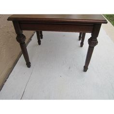 a small wooden table sitting on top of a sidewalk