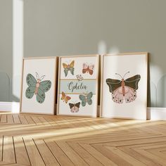 three framed butterfly prints sitting on top of a wooden floor