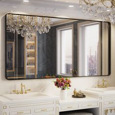 a bathroom with two sinks and a large mirror over it's sink area, along with a chandelier hanging from the ceiling