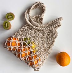 an orange and kiwi fruit in a net bag