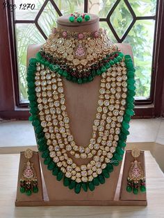 an elaborate necklace and earring set on display in front of a window with the words,