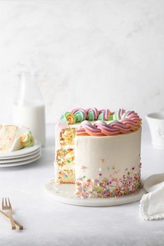 a white cake with sprinkles and colorful frosting