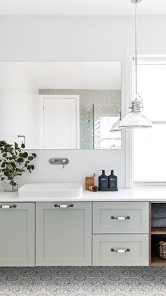 a bathroom with white cabinets and gray flooring