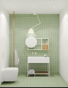 a green tiled bathroom with a white sink and toilet next to a shelf on the wall