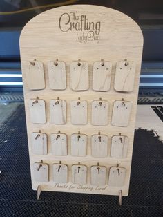 the crafting lady's wooden calendar is displayed on a stand with clothes pins attached to it