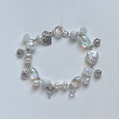 A sweet handmade bracelet ✿ Made with freshwater pearls, glass crystal beads, metal accents, and natural stone ✿ Pearlescent white, iridescent clear, marbled white, milky white, and silver ✿ Toggle Clasp. Some beads may be added or removed depending on the length selected Cute Handmade Bracelets, Cute Charm Bracelets, Crystal Bracelets Diy, Cute Beads, Handmade Charm Bracelets, Beaded Charm Bracelet, Jewelry Accessories Ideas, Dope Jewelry, Moon Glow