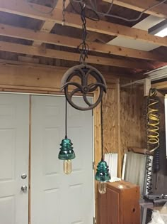 three lights hanging from the ceiling in a room with wood paneling and white doors