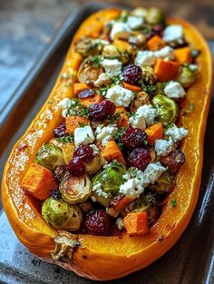 an orange squash filled with vegetables and feta cheese