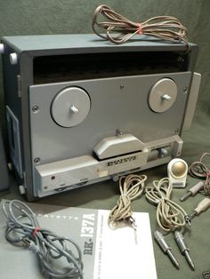 an old stereo is sitting on the table next to some wires and headphones are plugged into it