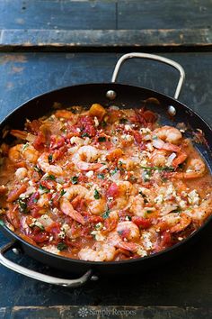 a skillet filled with cooked shrimp in tomato sauce