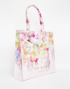 a white bag with flowers painted on the front and sides, sitting against a white background