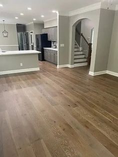 an empty living room with hard wood floors