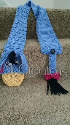 a crocheted stuffed animal is sitting on the stairs next to a knit scarf