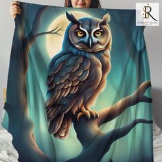 a woman holding up a blanket with an owl on it