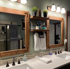 a bathroom with two sinks and mirrors in it's center, along with towels hanging on the wall