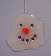 a glass ornament with an orange nose and black eyes on it's side