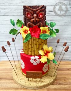 a cake decorated with flowers and tiki head