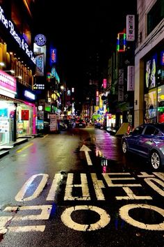 a city street at night with neon lights