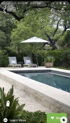 a pool with chairs and an umbrella next to it in the middle of a yard