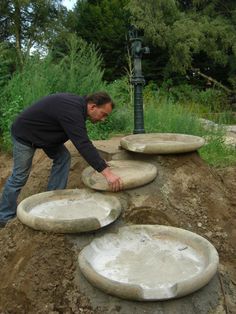 a man placing cement plates on top of a hill